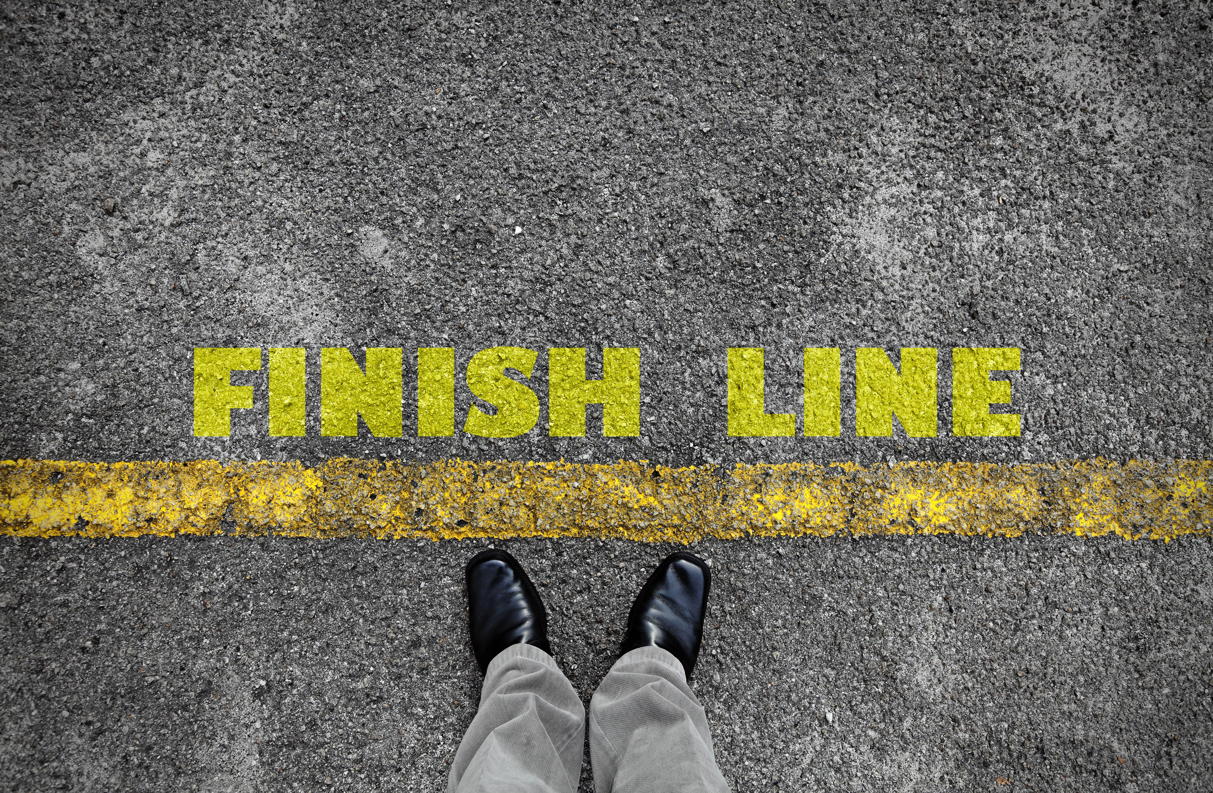 Finish line written in yellow text on a roadway